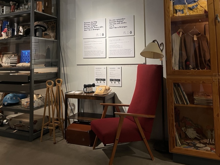 The Mölndal installation: the Ericsson Dialog on a side table beside the red armchair, posters on the wall.